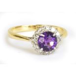 An 18ct yellow gold and platinum tipped diamond and amethyst ring, the central amethyst within a