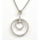 A white metal diamond set circular pendant, suspended on a white metal chain stamped 10k, overall