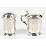 ALBERT EDWARD JONES; a George V hallmarked silver Arts & Crafts three piece condiment set of