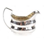 MATTHEW WEST; a George III Irish hallmarked silver cream jug of oval form of simple reeded loop