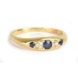 A yellow metal five stone dress ring set with sapphires and diamonds, size L 1/2, approx 3.3g.