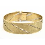 A 9ct yellow gold textured flat link bracelet with angled bands of pierced decoration, length 19.