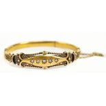 A late Victorian/Edwardian 15ct yellow gold filigree decorated and five stone diamond hinged bangle,