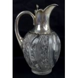 A late Victorian hallmarked silver mounted and wrythen cut glass claret jug with hinged lid above