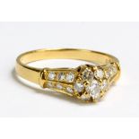 An 18ct yellow gold and diamond daisy cluster ring, the round cut stones in high claw setting