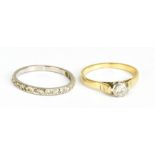 A yellow metal single stone diamond solitaire ring, size Q, and a white metal half eternity ring,