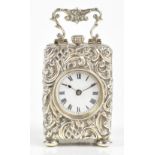 HENRY MATTHEWS; an Edward VII hallmarked silver cased dressing table clock with repoussé detail