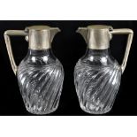 JOSEF KRISCHER; a pair of German 800 grade silver mounted claret jugs, with clear glass bodies,