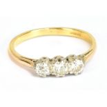 An 18ct yellow gold and diamond three stone ring, the central round brilliant cut stone approx 0.
