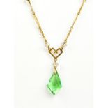 A 9ct yellow gold fine link open work chain suspending clear glass bead spacers and a green glass