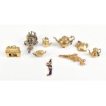 A group of nine 9ct gold charms, including pistol, telephone and kettle, combined approx 23.8g.