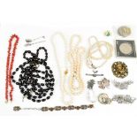 A small group of costume jewellery including a graduated cherry amber coloured beaded necklace,