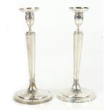 A pair of Continental white metal candlesticks with chased and cast floral detail, indistinct