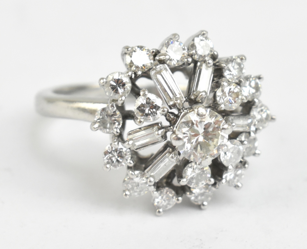 A platinum diamond cluster ring set with brilliant and baguette cut stones, the central diamond