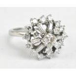 A platinum diamond cluster ring set with brilliant and baguette cut stones, the central diamond