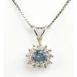 A white metal diamond and blue stone cluster pendant suspended from a white metal chain stamped 750,