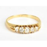 An 18ct yellow gold and diamond five stone ring, the central stone weighing 0.10cts, size L 1/2,
