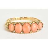 A late Victorian/Edwardian yellow metal coral and diamond chip ring set with five graduated coral