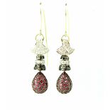 A pair of Eastern-style white metal drop earrings pavé-set with white and black diamonds and rubies,