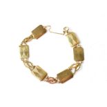 A 9ct gold bracelet consisting of six rectangular panels separated by two diamond-shaped links,