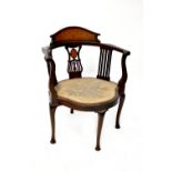 An Edwardian mahogany tub chair with urn and floral inlay to the back,