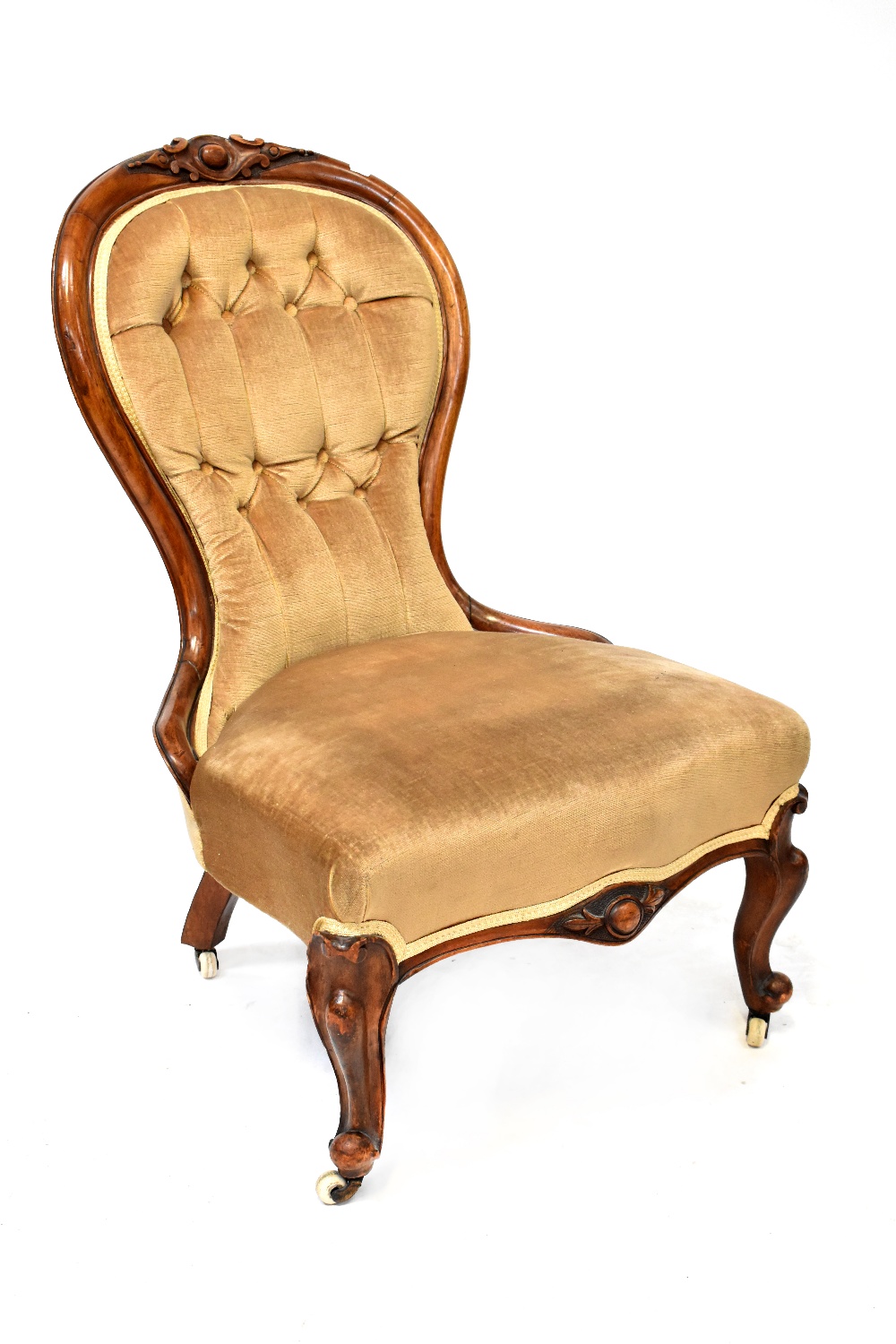 A Victorian walnut-framed spoon-back chair, front cabriole carved supports to castors.