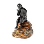 A good Japanese Meiji period bronze figure of a seated peasant smoking a pipe and mounted on a
