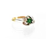 An 18ct gold emerald and diamond crossover ring,