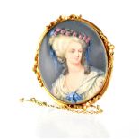 A portrait watercolour miniature of a young Georgian lady in a yellow metal scrolling frame brooch,