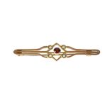 An Edwardian 9ct yellow gold bar brooch set with central garnet and four seed pearls, approx 2.5g.