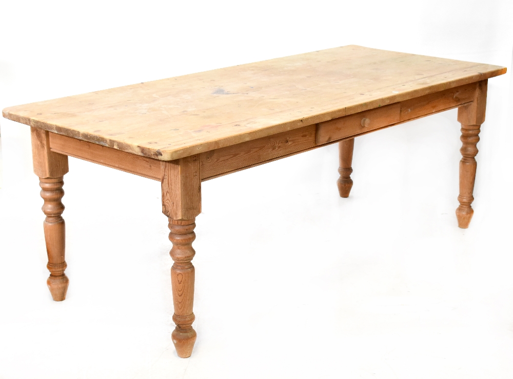 An Edwardian large pine country kitchen table with one side drawer, to baluster supports,
