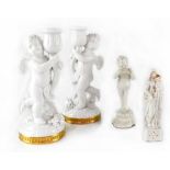 A pair of white glazed gilt-heightened cherubic candlesticks,