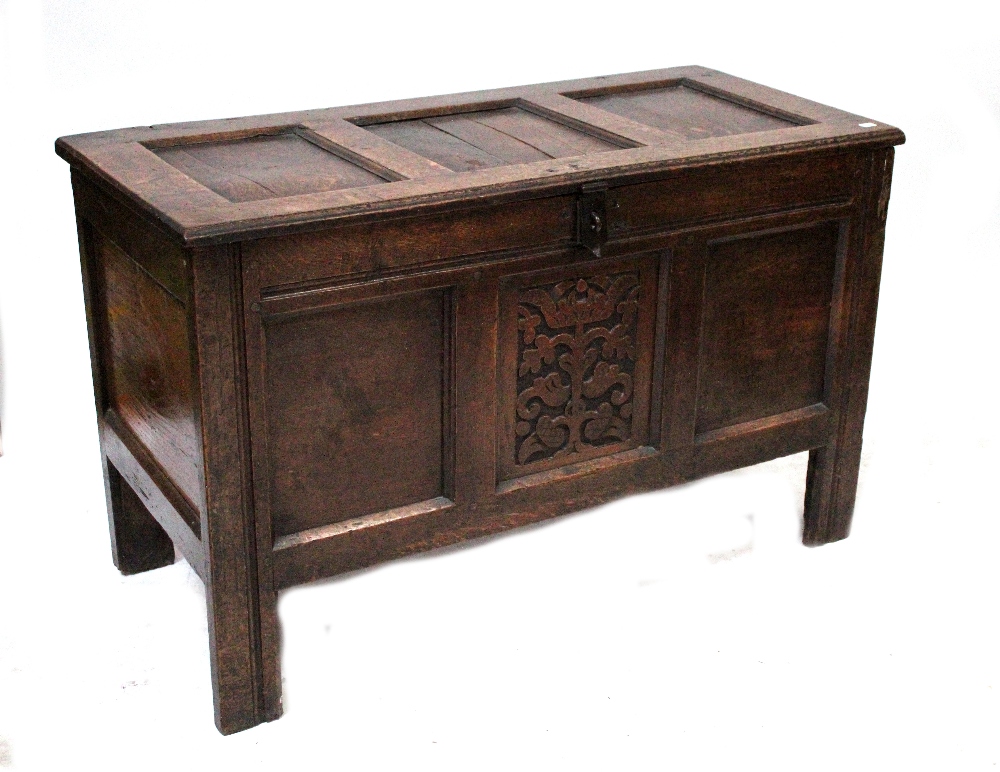 A 19th century oak three-panel coffer with hinged lid above carved central front panel and raised