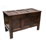 A 19th century oak three-panel coffer with hinged lid above carved central front panel and raised