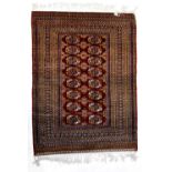 An Eastern red ground rug with central panel surrounded by stepped geometric border,