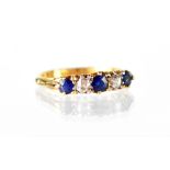 An 18ct five-stone diamond and sapphire ring,