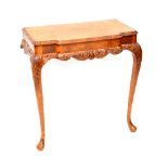 A reproduction walnut break-front console table with carved apron and acanthus leaf decorated