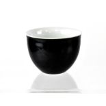 A black Oriental bowl with pale blue interior and with four character marks to base, diameter 6.5cm.