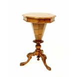 A Victorian walnut sewing table of trumpet form with octagonal top, on carved tripod base,