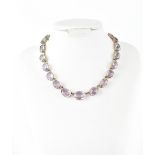 A yellow metal necklace filigree set with twenty-three pale amethysts, length 38cm.