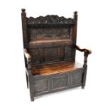 An antique and later carved box seat settle,
