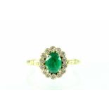 An 18ct gold cluster ring set with central oval-cut emerald surrounded by fourteen diamonds,