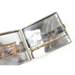 A Japanese themed silver cigarette case, Japanese landscape decoration enhanced with copper tones,