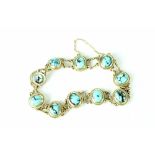 A 9ct gold bracelet set with ten marbled turquoise coloured stones.