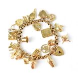 A 9ct gold charm bracelet with twenty charms and heart-shaped clasp, weight 28.3g.