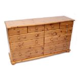 A large contemporary pine chest with four small frieze drawers over six lower drawers,