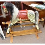 A mid-20th century rocking horse painted in dapple grey, raised on pine base, height 103cm.