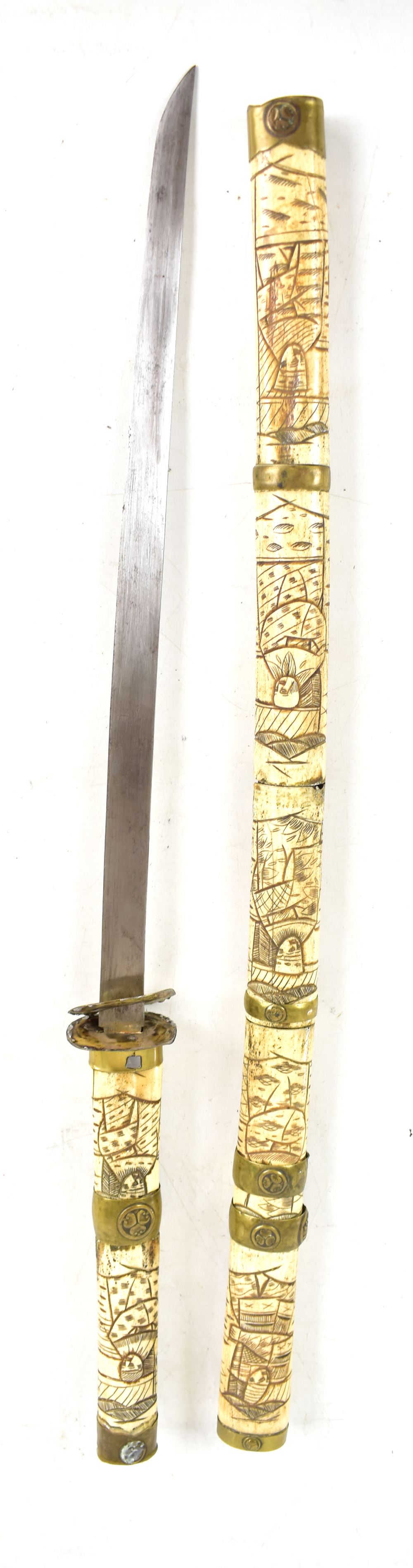 A Japanese bone handled wakizashi with brass mounts featuring stylised mon, length of blade 43.