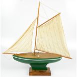 A mid-20th century green painted pond yacht raised on oak plinth base, height 65cm.Additional