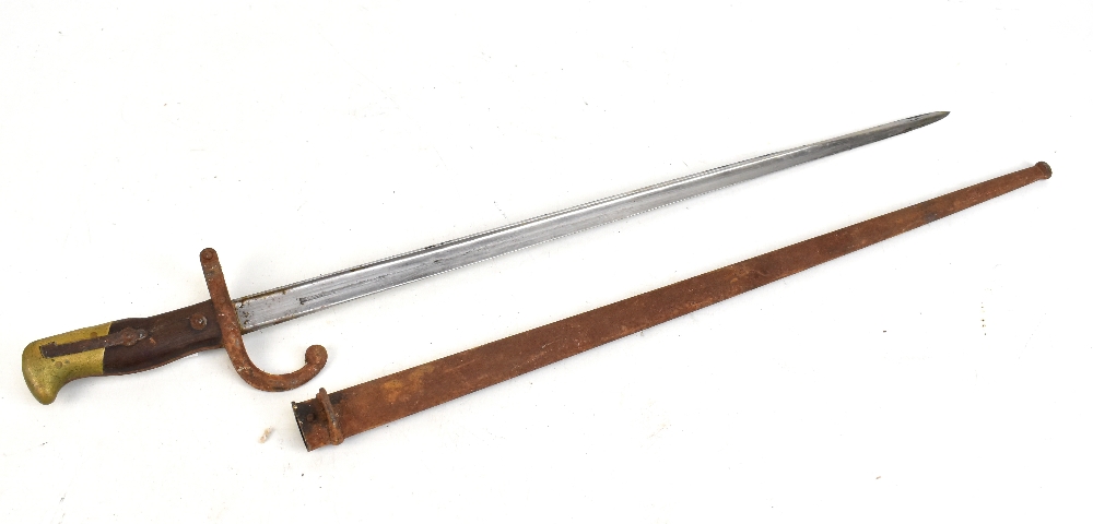 A late 19th century French bayonet, the blade back signed and dated 1879, length of blade 52cm, with